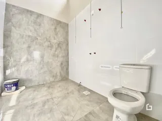Foto de um banheiro com piso e paredes revestidos de cerâmica.
