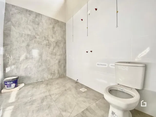 Foto de um banheiro com piso e paredes revestidos de cerâmica.