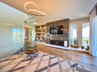 Sala de estar moderna com piso de madeira e lareira em um apartamento em Lajeado.