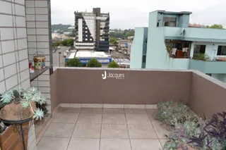 Vista externa de uma área de terraço com piso de cerâmica e vegetação.