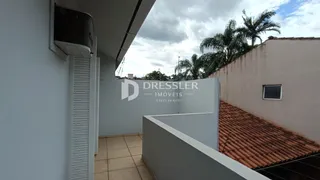 Vista da fachada de uma residência com telhado de telhas de barro e parede branca.