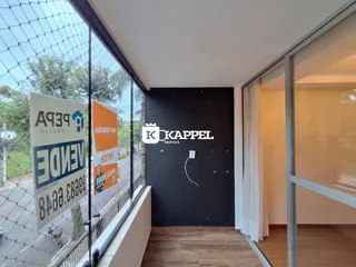 Vista da sala de estar com grande janela e área externa.