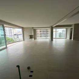 Foto de um ambiente interno amplo com piso claro e iluminação natural.