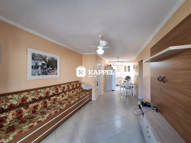 Uma sala de estar com sofá e decoração em tons neutros e terrosos.
