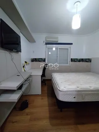 Quarto com cama e piso de madeira clara.