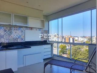 Vista da sala de estar com grandes janelas que oferecem uma vista panorâmica.