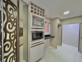 Interior de uma sala com armários brancos e piso de cerâmica.