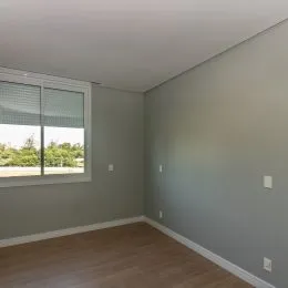 Ambiente interno com paredes cinzas e piso de madeira.