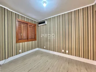 Sala com revestimento de parede listrado e piso de madeira clara.