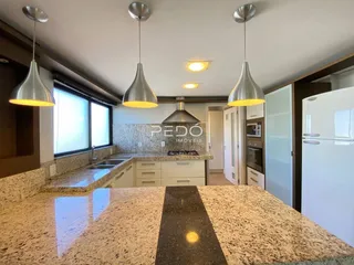 Cozinha moderna com bancadas de granito e armários brancos.
