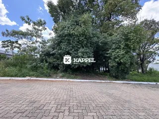 Foto externa mostrando a entrada de uma propriedade com vegetação densa ao fundo.