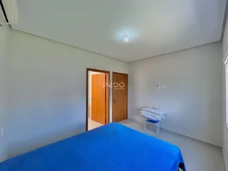 Quarto com paredes cinzas e cama azul.