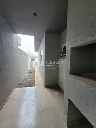 Corredor interno de uma residência com paredes brancas e piso claro.