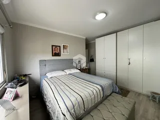 Quarto com cama e armários brancos em um imóvel no Brasil.