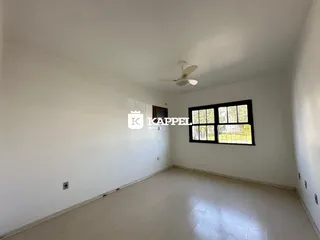 A sala de estar branca apresenta uma grande janela.