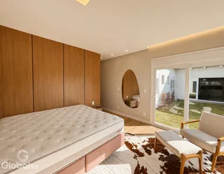 Quarto com cama grande e painéis de madeira na sala de estar.