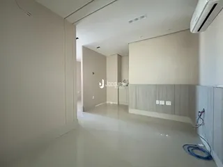 Hall da casa com piso claro e paredes brancas.