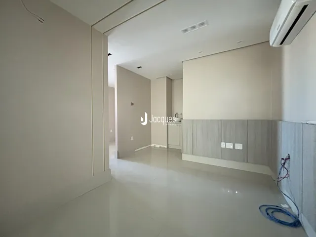 Hall da casa com piso claro e paredes brancas.