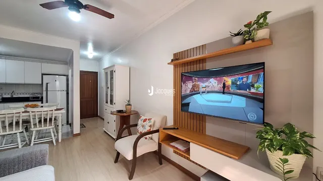Sala de estar com decoração moderna e móveis de madeira clara.