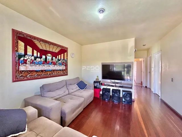 Sala de estar com sofá e piso de madeira em um imóvel no Brasil.