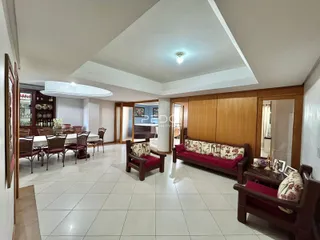 Ambiente interno de uma sala de jantar e estar com piso de cerâmica clara.