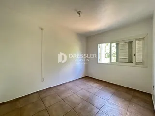 Interior de um cômodo com piso de cerâmica e paredes brancas.