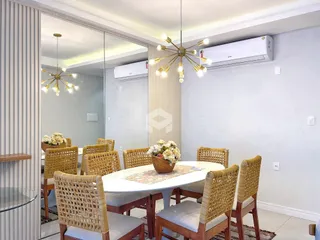 Uma sala de jantar com mesa redonda e cadeiras de vime em um ambiente claro.