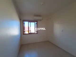 Vista interna de um cômodo com paredes brancas e piso claro.