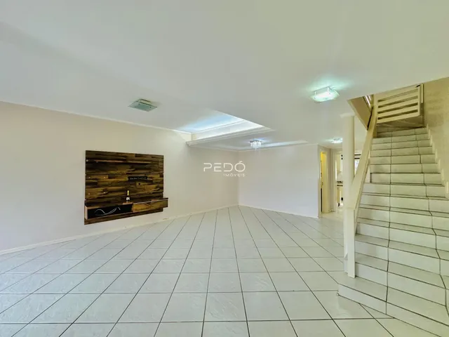 Ambiente interno de uma sala com piso de cerâmica e parede de madeira.