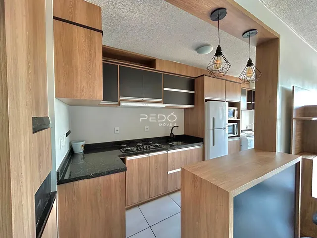 Cozinha moderna com armários de madeira e bancadas escuras.