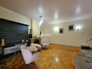 Sala de estar com piso de madeira e lareira em um imóvel no Brasil.