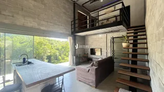 Vista interna de uma área comum com grande janela e escadaria em um imóvel no Brasil.