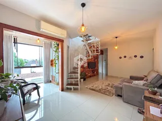 Sala de estar ampla com piso de cerâmica e grandes janelas.