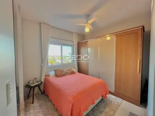 Quarto com cama e armários de madeira no imóvel.