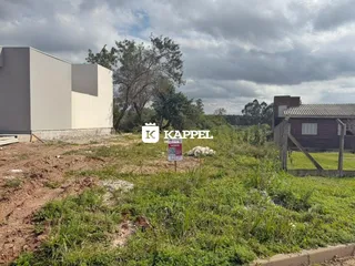 Vista externa de um terreno com construções e vegetação rasteira.