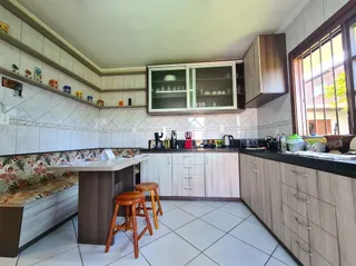 Vista interna de uma cozinha com armários e piso cerâmico.