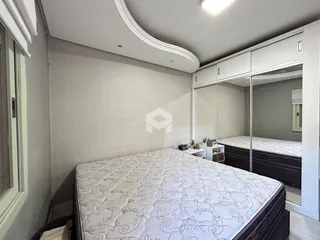 Quarto com cama e armários em um ambiente claro.