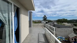 Vista panorâmica da varanda com paisagem urbana e montanhas ao fundo.