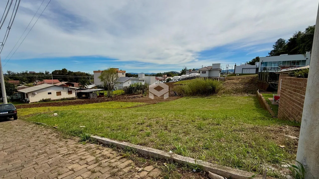 Vista da propriedade com gramado e rua no primeiro plano.