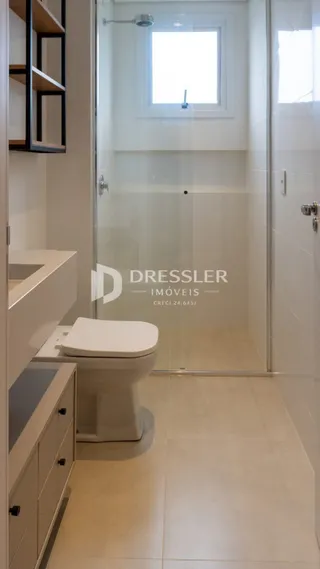 Foto de um banheiro moderno com box de vidro e revestimento claro.