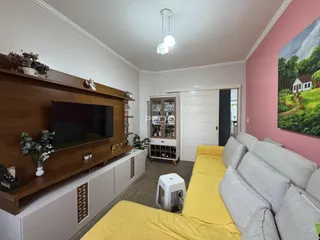 Sala de estar com sofá e painel de madeira.