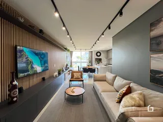 Sala de estar moderna com painel de madeira e televisão.