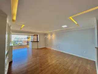 Sala de estar com piso de madeira e vista para a cidade.