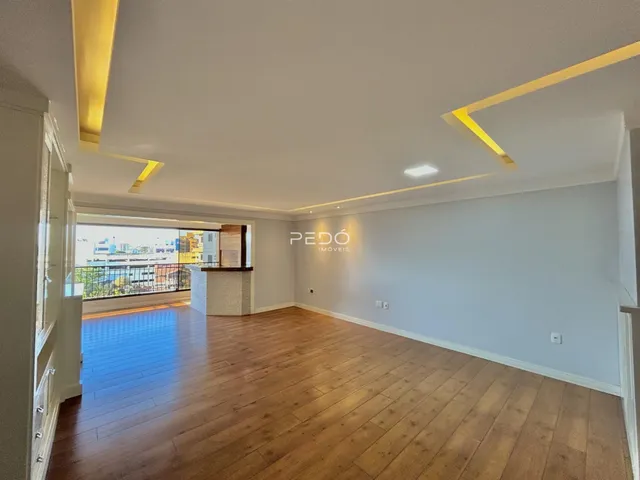 Sala de estar com piso de madeira e vista para a cidade.