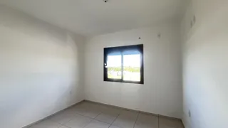 Ambiente interno de uma sala com paredes brancas e piso de cerâmica.