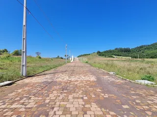 Vista da estrada rural em Lajeado, Brasil, com campo aberto.