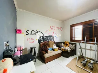 A sala de estar apresenta uma parede decorada com frases e um sofá marrom.