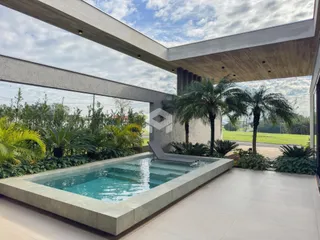 Vista de uma piscina externa com paisagem tropical.