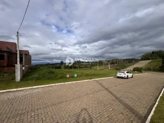 A foto mostra a fachada de uma propriedade em Lajeado, Brasil, com uma estrada e vegetação ao redor.