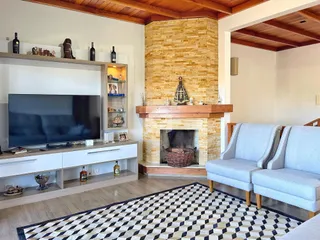 Sala de estar com lareira de pedra e decoração rústica.